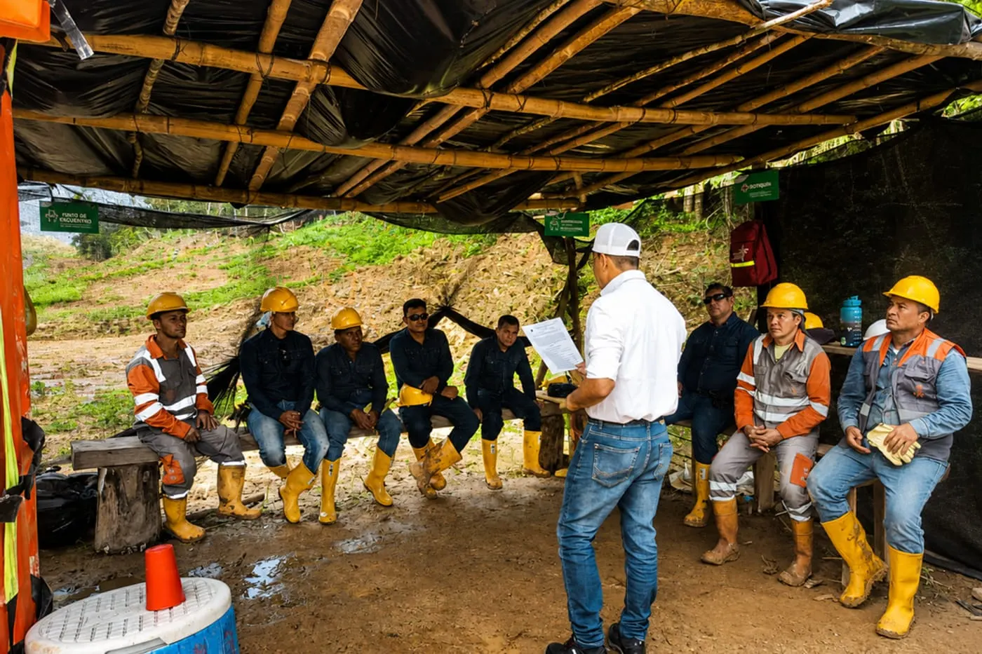 Auditoría de campo con una cuadrilla de trabajadores reunida en obra.