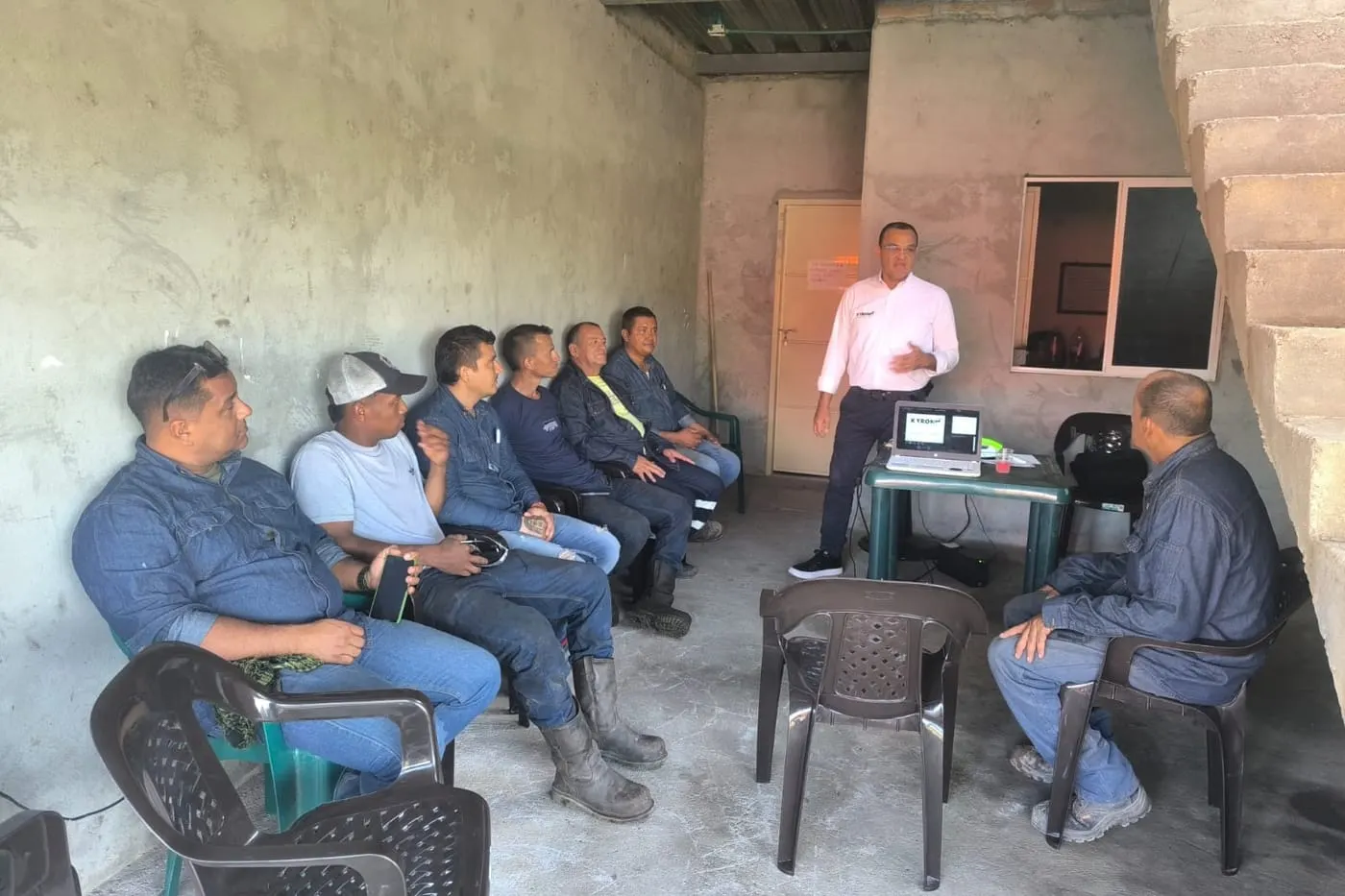 Profesional de KYRON dictando una capacitación de seguridad a un grupo de operarios.
